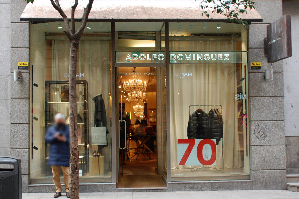 Una persona pasa por delante de un tienda Adolfo Domínguez