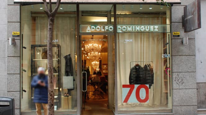 Una persona pasa por delante de un tienda Adolfo Domínguez
