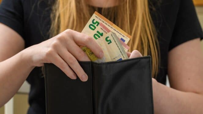 Mujer guarda dinero en su cartera