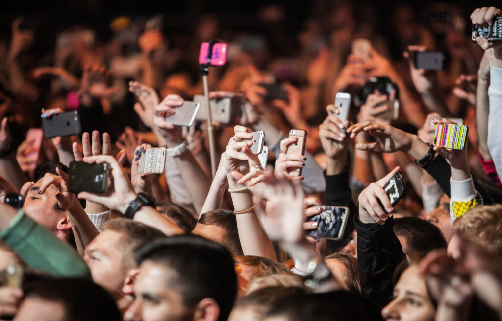 Personas usando el móvil durante un concierto