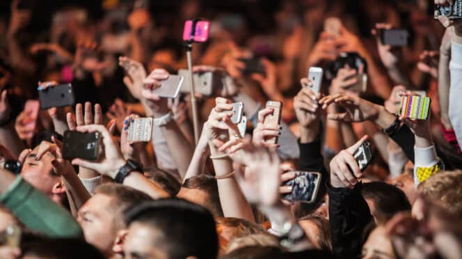 Personas usando el móvil durante un concierto