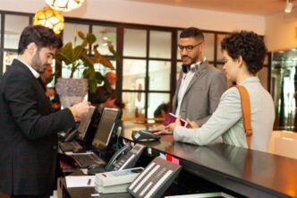Clientes hablan con el recepcionista del hotel