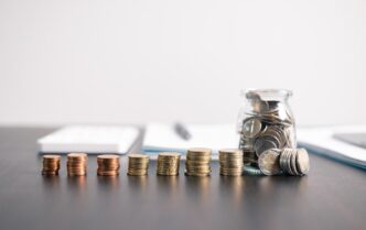 6 pilas de monedas en fila encima de una mesa