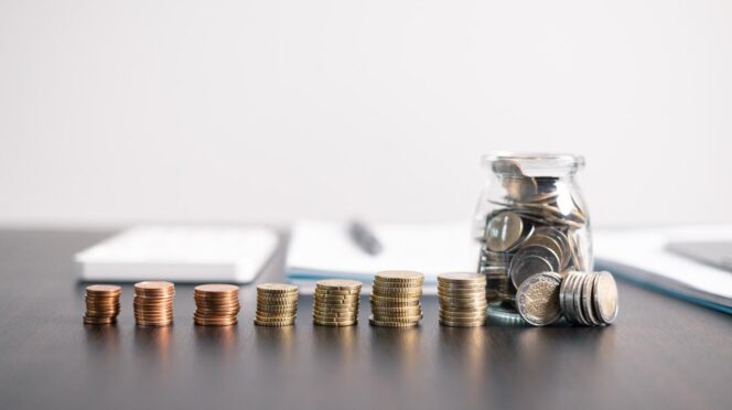 6 pilas de monedas en fila encima de una mesa