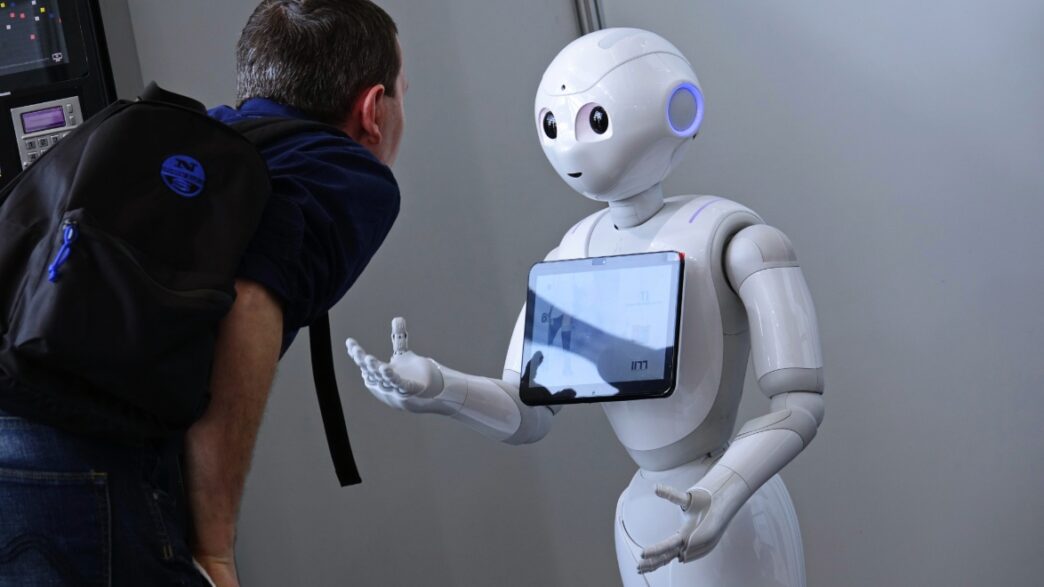 Un robot enseñando a un chico