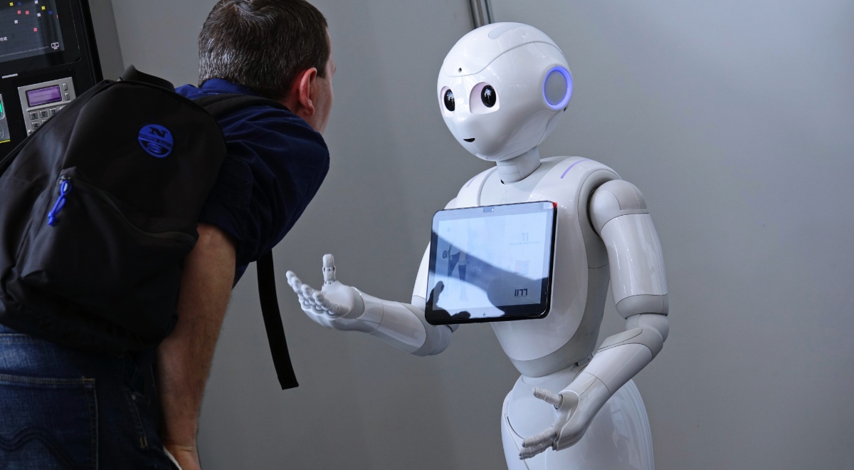 Un robot enseñando a un chico