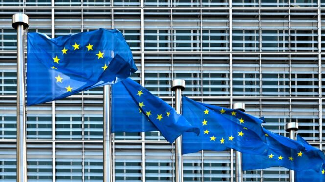 Banderas de la UE frente al edificio de la comisión del consejo de la unión europea en berlaymont