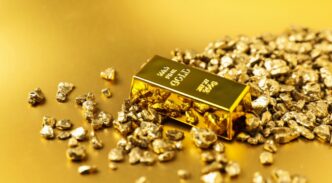 Pepitas de oro y barra sobre fondo brillante