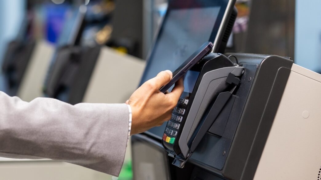 Hombre utilizando su móvil para pagar