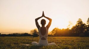 Mujer joven practicando yoga en la naturaleza.