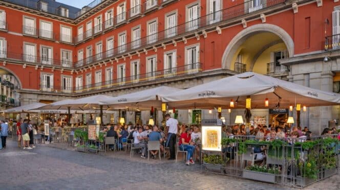 Personas en un restaurante al aire libre en la Plaza Mayor de Madrid, España