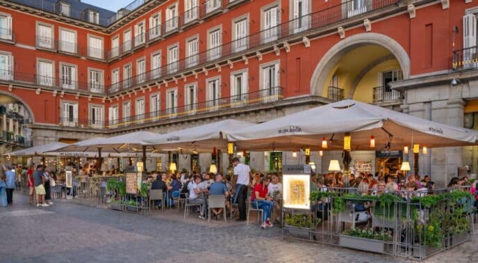 Personas en un restaurante al aire libre en la Plaza Mayor de Madrid, España