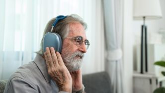 Hombre mayor escuchando música con auriculares