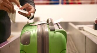 Persona etiquetando una maleta verde