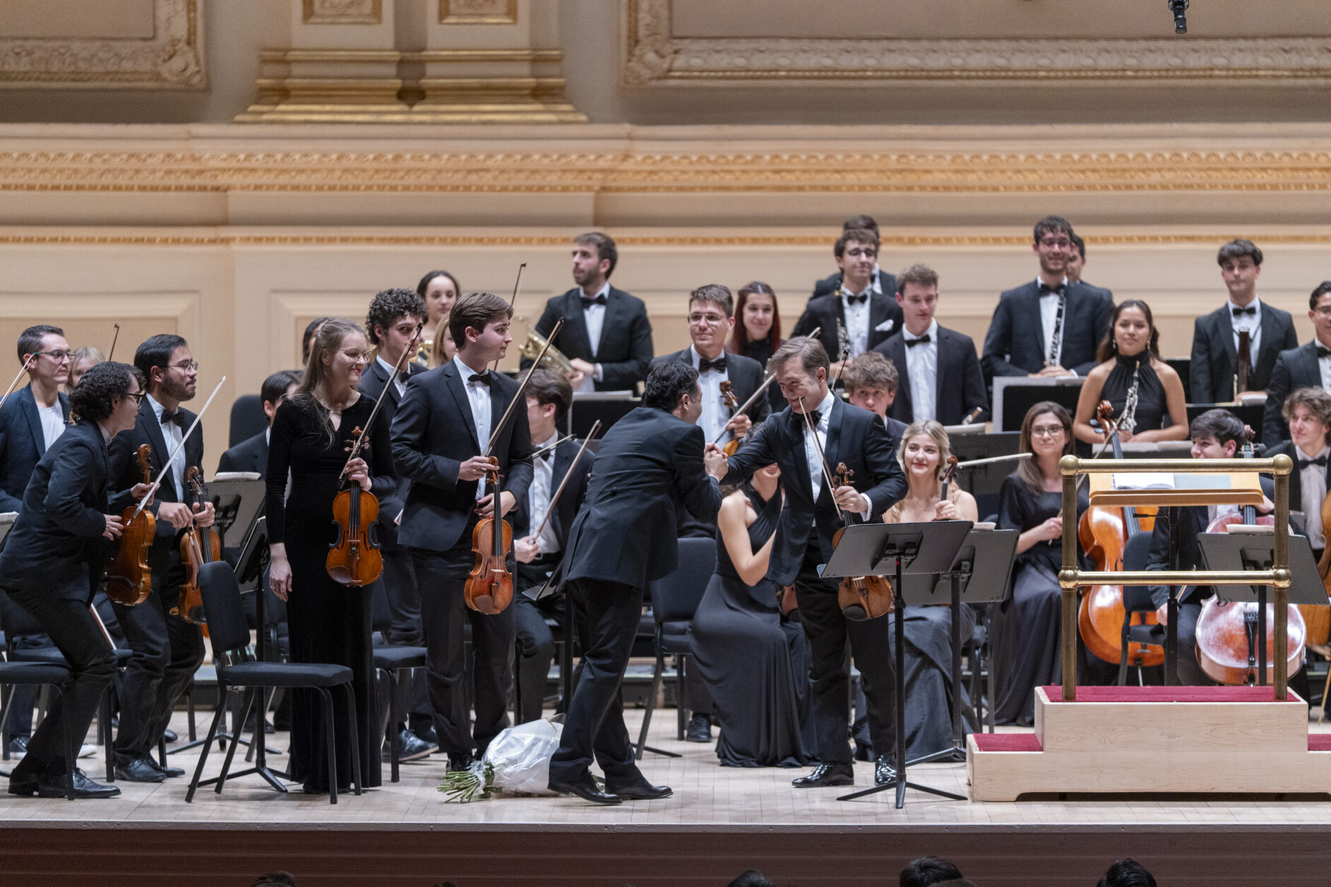 Director y violín solista se saludan tras el concierto 