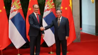 El primer ministro de China, Li Qiang y el primer ministro de Serbia, Đuro Macut, dándose la mano.