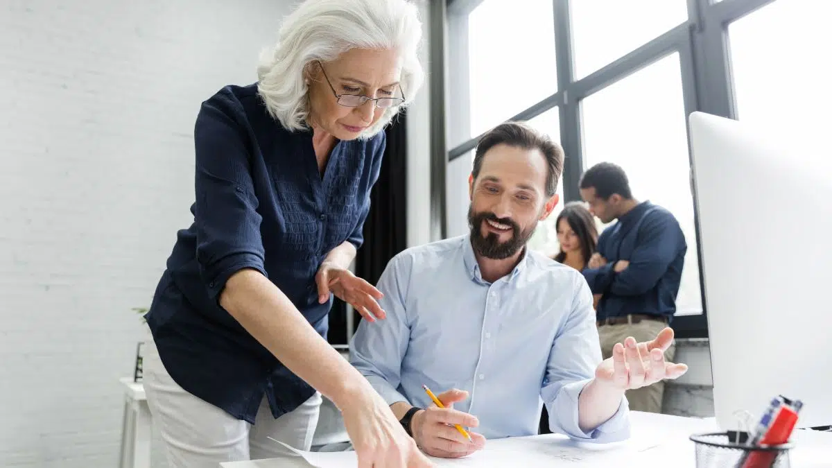 Perfil senior enseñando a compañero más joven