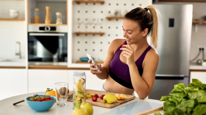 Una mujer preparando un batido de frutas