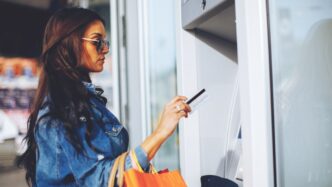 Una chica sacando dinero de un cajero